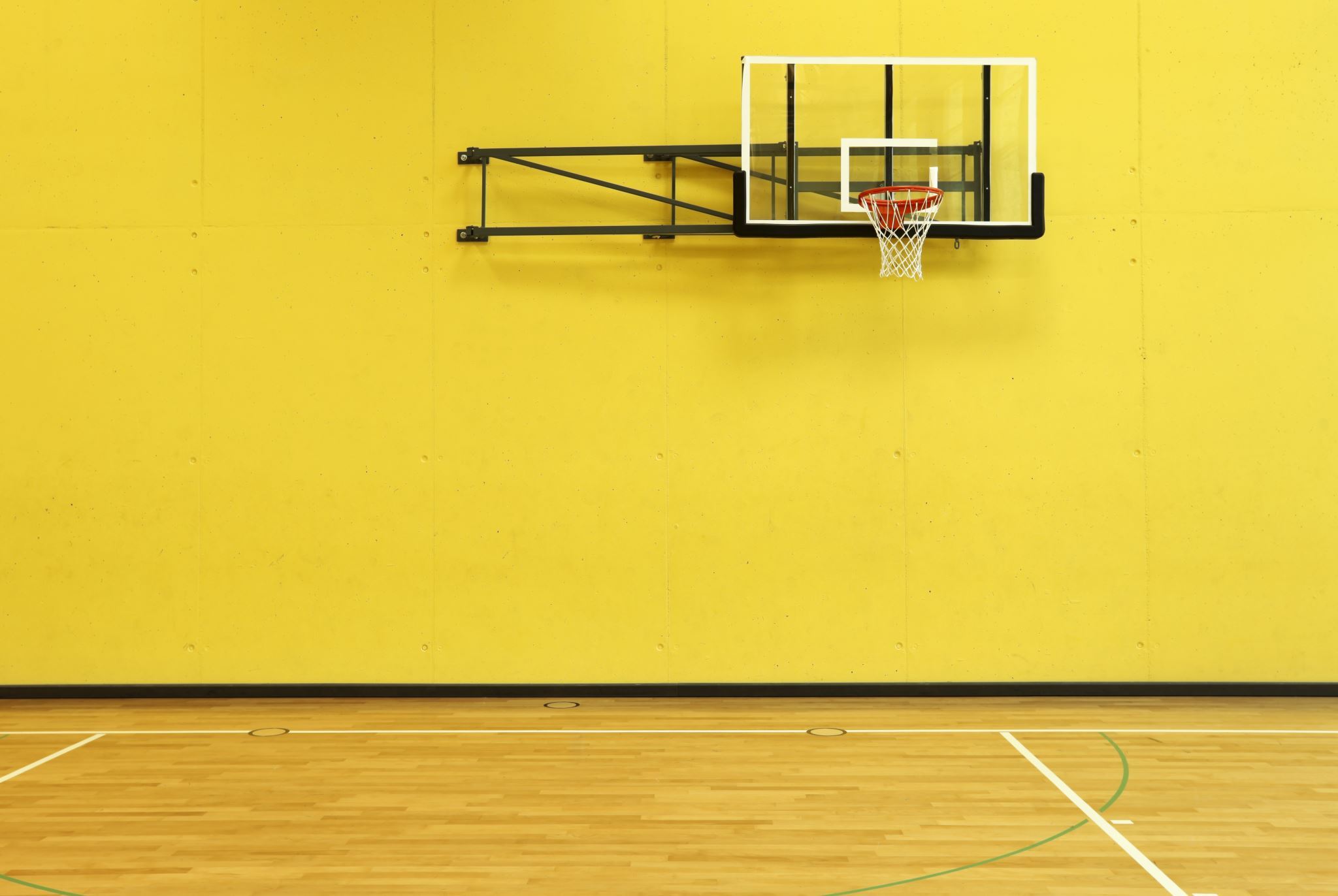 公立学校の黄色の壁とバスケットボールのリング